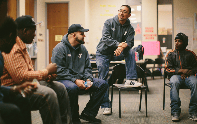 Group of returning citizens speaking to each other about their experiences.