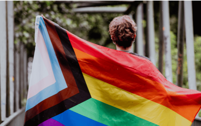 Youth carrying a pride flag.